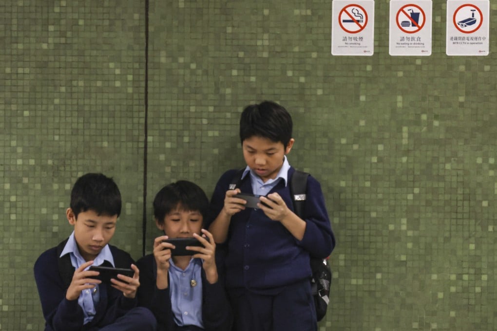 Students looking at their mobile phones at Lok Fu MTR station in 2024. Photo: Jelly Tse