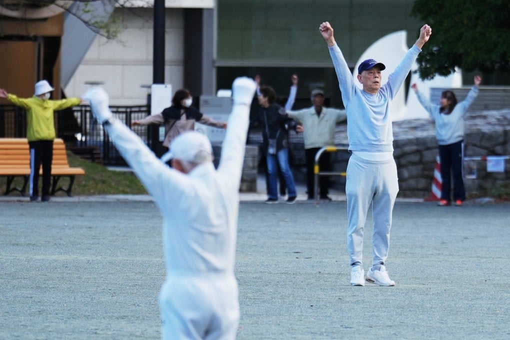 People perform a stretching exercise while listening to a Radio Taiso programme in a public park in Tokyo, Japan, on April 6, 2026. Photo: AP