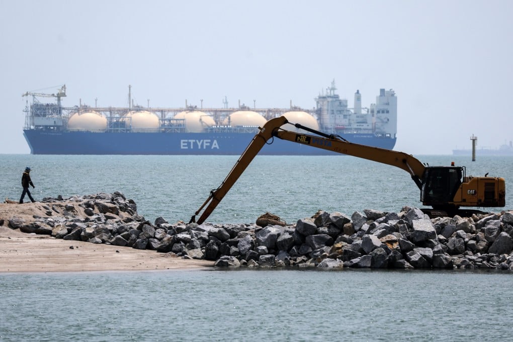 A worker walks past a liquefied natural gas tanker in the Malacca Strait on April 15. Photo: EPA