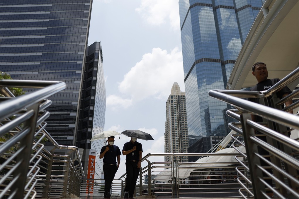 Office workers walk with umbrellas to shield themselves from the sun during hot weather in Bangkok, Thailand, last month. Photo: EPA