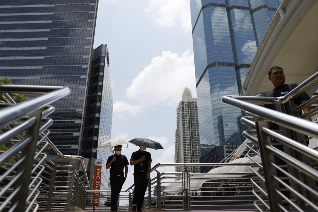 Office workers walk with umbrellas to shield themselves from the sun during hot weather in Bangkok, Thailand, last month. Photo: EPA