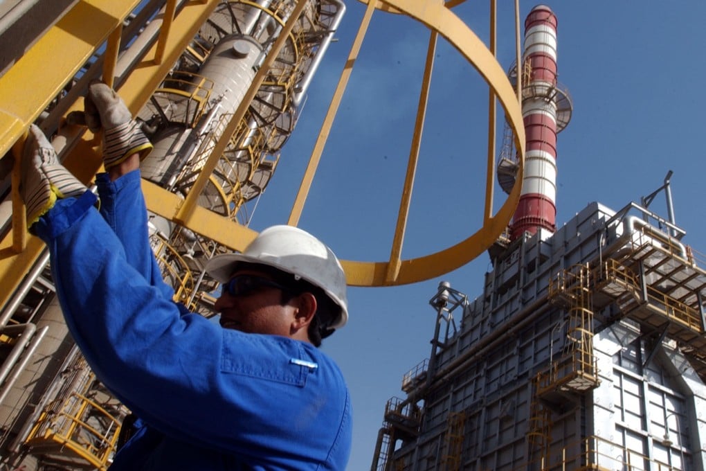 An oil technician climbs down a tower at a refinery in Jebel Ali, UAE. Photo: AP