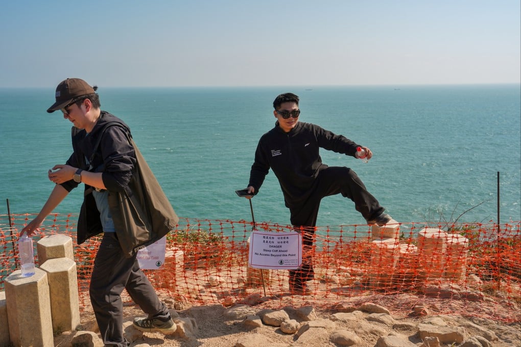 A man crosses a hazard warning boundary after taking pictures near the edge of a cliff on the way to the Po Pin Chau Viewing Platform at High Island Reservoir’s East Dam on January 3. Photo: Elson Li
