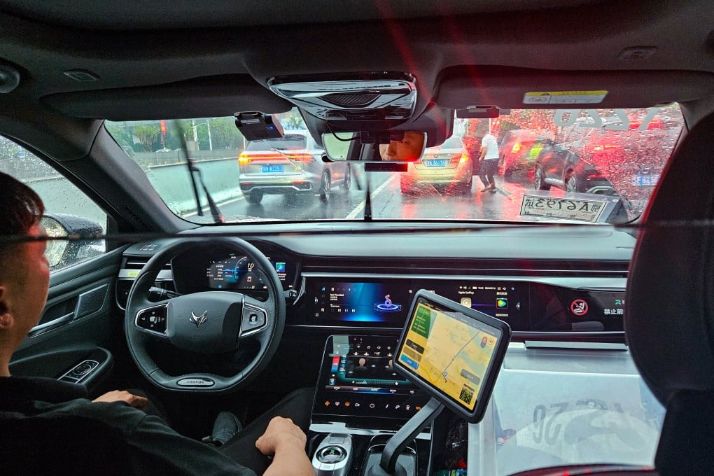 A safety operator sits in the driver’s seat of an Apollo Go robotaxi as the vehicle travels to Wuhan Tianhe International Airport. Photo: Coco Feng