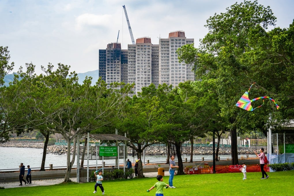 Residents fly kites at Tai Po Waterfront Park, Hong Kong, in February, with the burnt buildings of Wang Fuk Court in the background. Photo: Eugene Lee
