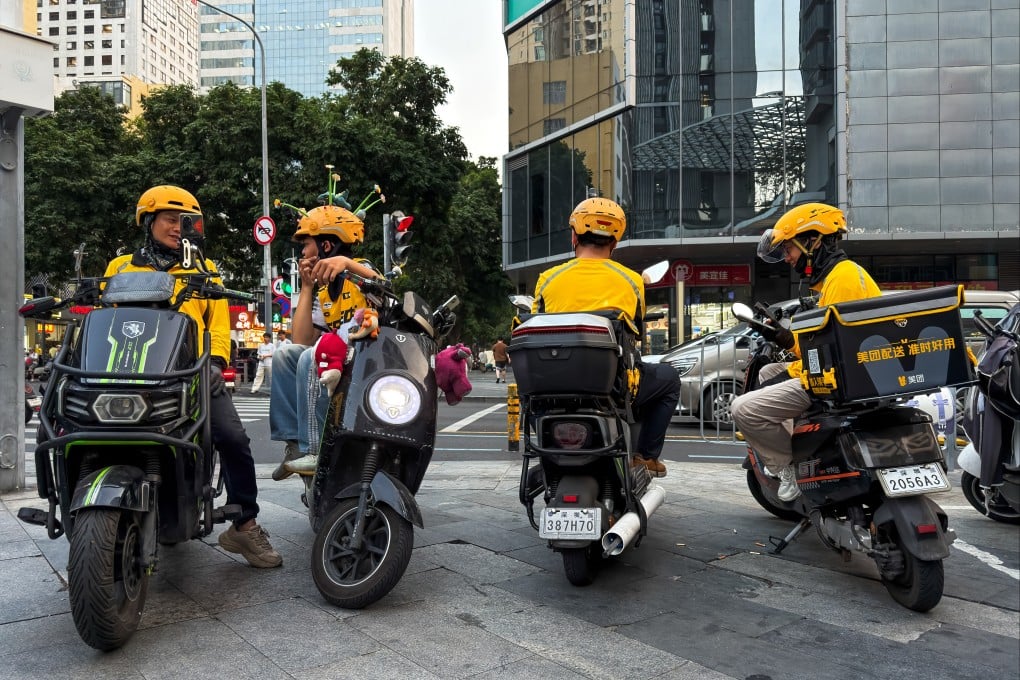 Delivery riders sit on scooters while waiting for orders at an intersection on March 24 in Shenzhen. Photo: Getty Images