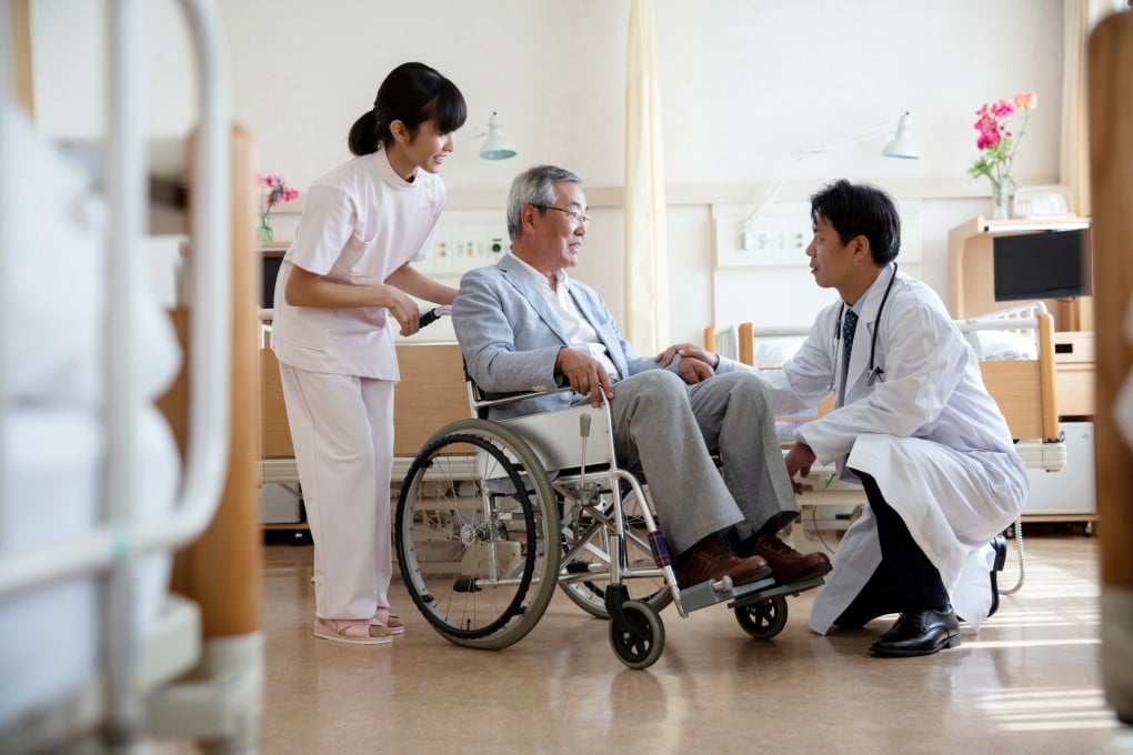 Male doctor discussing with senior man sitting on wheelchair in hospital ward Tokyo, Japan. Photo: Getty Images