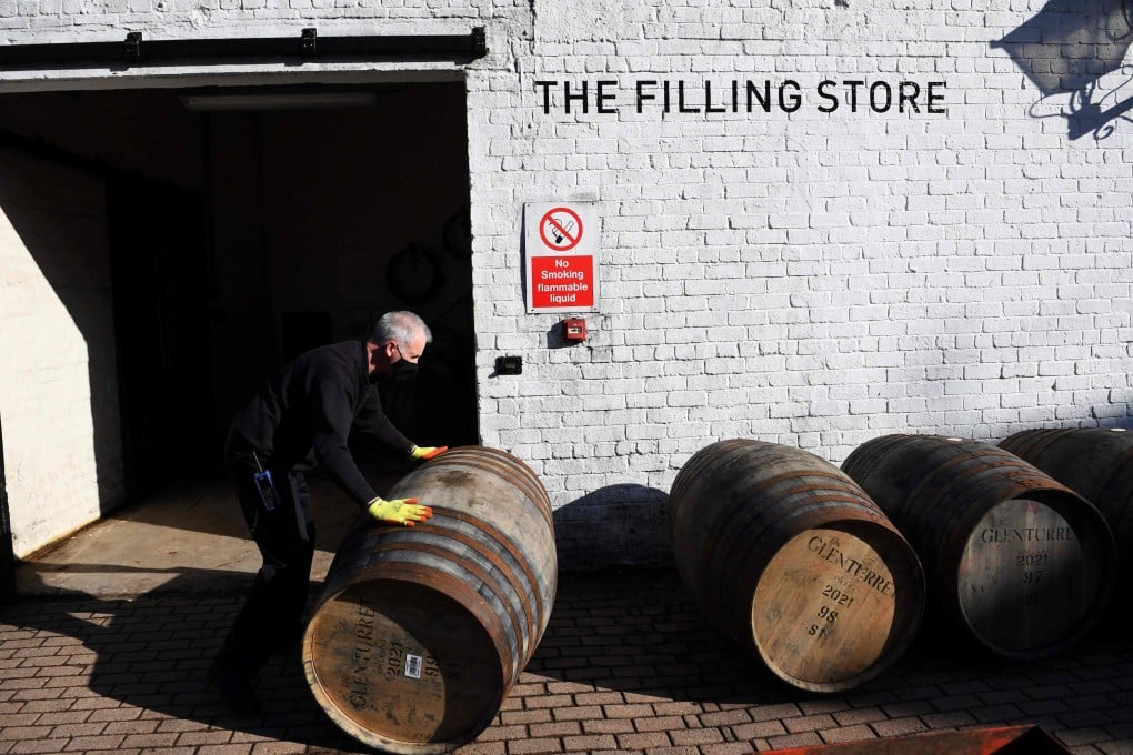An employee moves a whisky barrel out of the Filling Store at The Glenturret Distillery in Crieff, Scotland, in February 2021. Photo: AFP