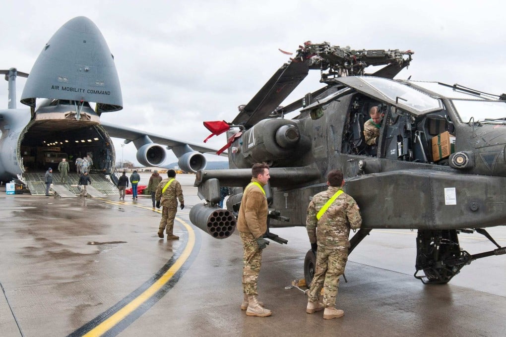 An AH-64 Apache attack helicopter stands in front of a Galaxy C-5 transport plane at the US Air Base in Ramstein, western Germany, in 2017. Photo: AFP
