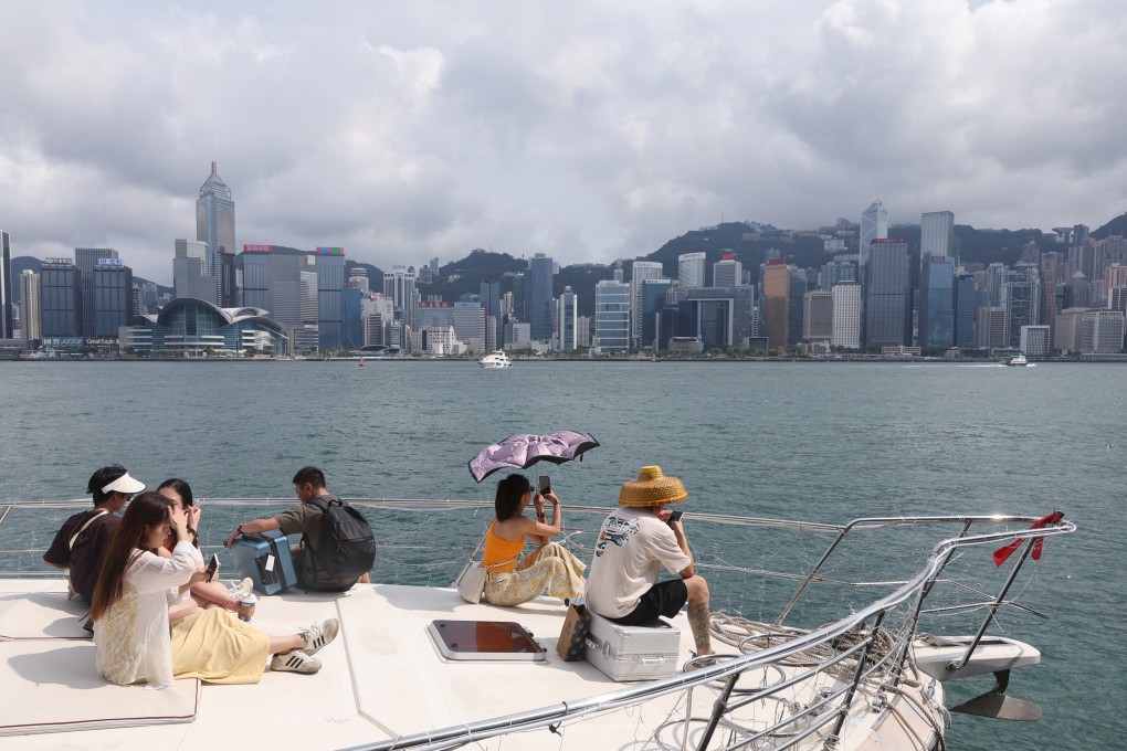 Tourists sit on a yacht sailing through Victoria Harbour on August 1, 2025. Photo: Edmond So