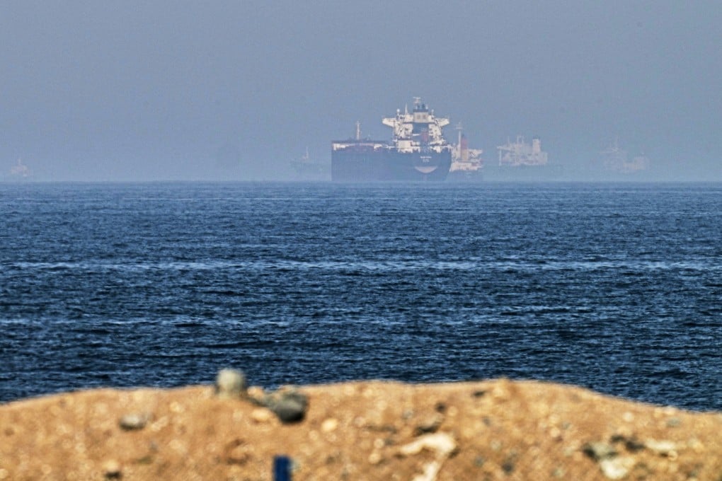 Cargo ships near the Strait of Hormuz, viewed from a rocky shoreline near Khor Fakkan, United Arab Emirates on Friday. On Sunday, an unidentified carrier in the strait reported being attacked by multiple small craft. Photo: AP