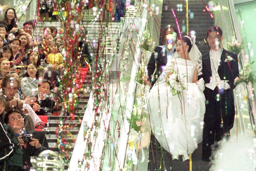 A couple rides an escalator during their wedding ceremony at Noksapyeong station in 2001. After opening in 2000 as a grandiose transport hub to serve a relocated Seoul City Hall that never happened, the station was forced to pivot in interesting ways. Photo: The Korea Times