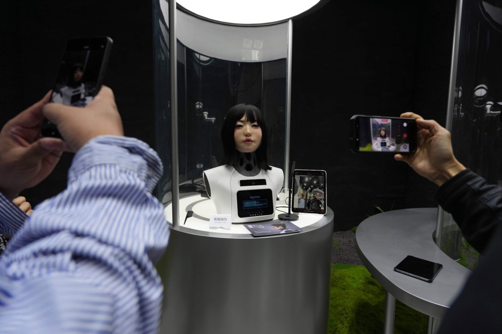 Visitors take pictures and videos of a human-like robot head on display at the Humanoid Robots Industry Base in Beijing’s Shougang Park on April 28. Photo: AP