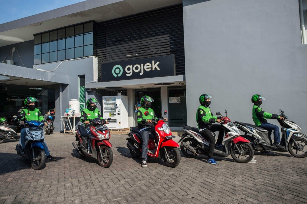 Gojek riders wait for their delivery orders at a distribution centre in Surabaya, Indonesia. Photo: AFP