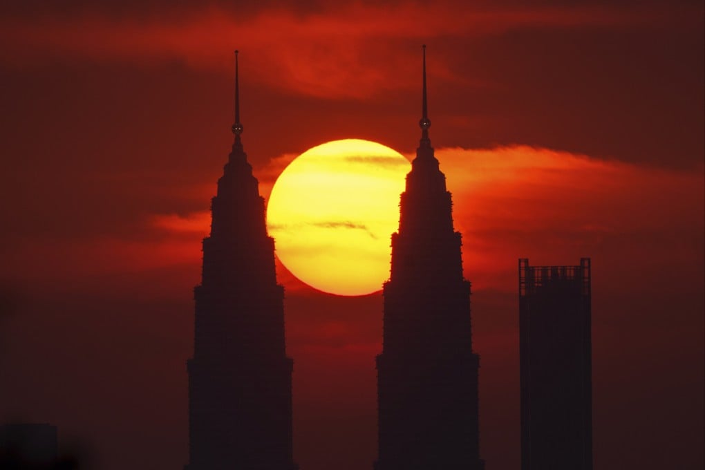 The sun sets behind the Petronas Twin Towers in Kuala Lumpur. Temperatures in Malaysia have soared to the mid-30s degrees Celsius. Photo: AP