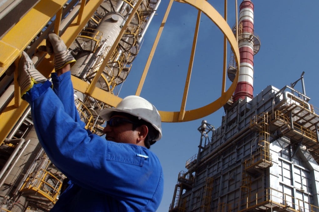 An oil technician climbs down a tower at a refinery in Jebel Ali, UAE. Photo: AP