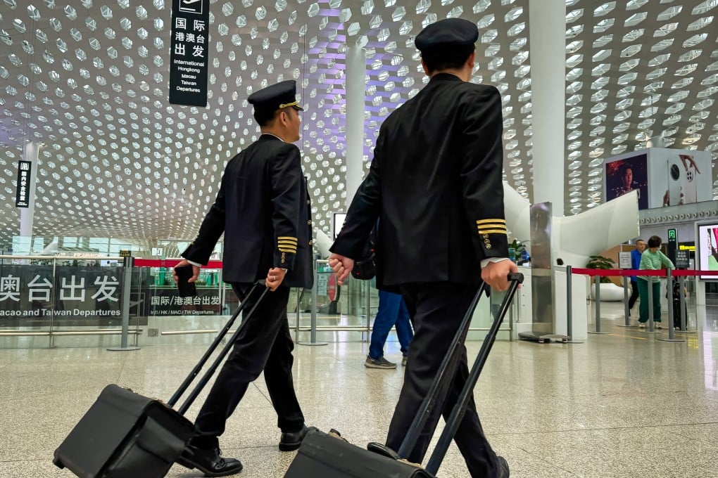 Two commercial airline pilots walk through the departure hall of Shenzhen Bao’an International Airport, as foreign pilots seeking to launch a career in China are warned of stiff competition and rigid standards. Photo: Getty