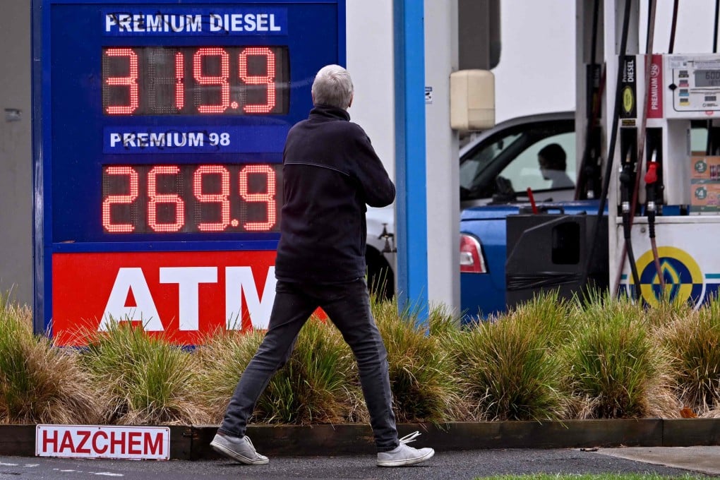 A pedestrian walks past a petrol station with fuel prices on display in Williamstown, Australia, on March 26. Photo: AFP