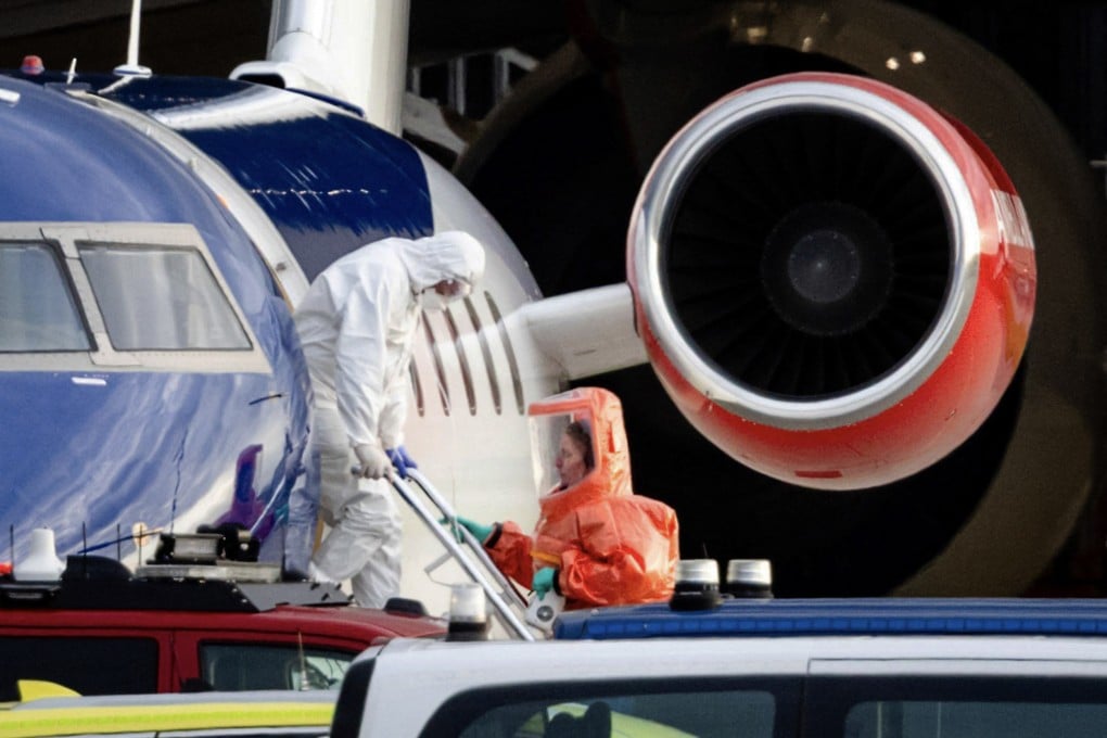 A person in a white hazmat suit disembarks a medical aircraft in Amsterdam on Wednesday. Photo: ANP via AFP