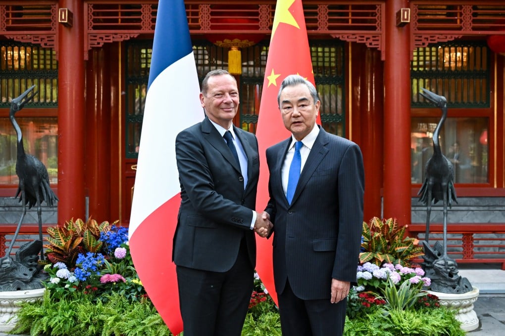 China’s top diplomat Wang Yi (right) shakes hands with Emmanuel Bonne, diplomatic adviser to the French president, in Beijing on May 8, 2026. Photo: Xinhua