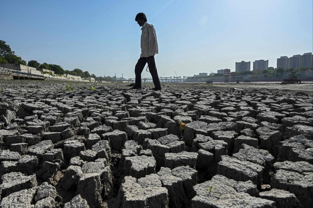 A man walks across the dry riverbed of the Sabarmati River in Ahmedabad, India, on May 8. Photo: AFP