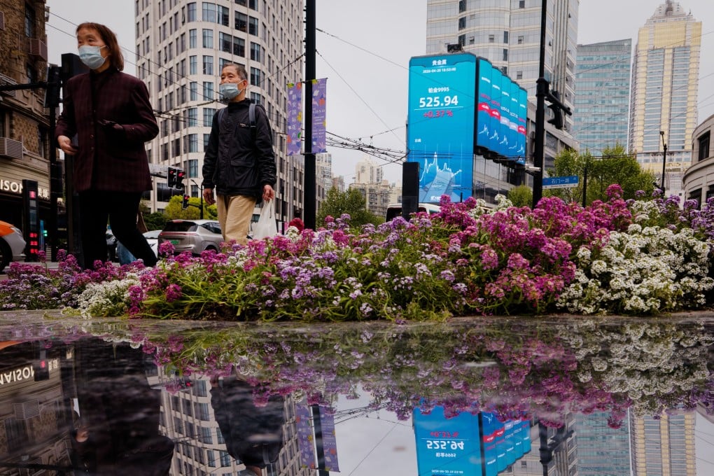 People walk beneath a large screen showing stock exchange and economic data in Shanghai. Asia-Pacific markets have seen gains in recent months as geopolitical panic over the Iran war dissipates. Photo: EPA