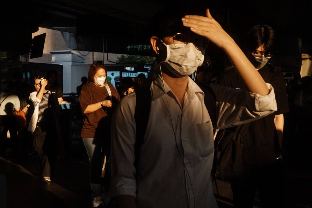 A man shields his face from the sunlight as he leaves a train station in Bangkok, Thailand, on April 29. Photo: AFP
