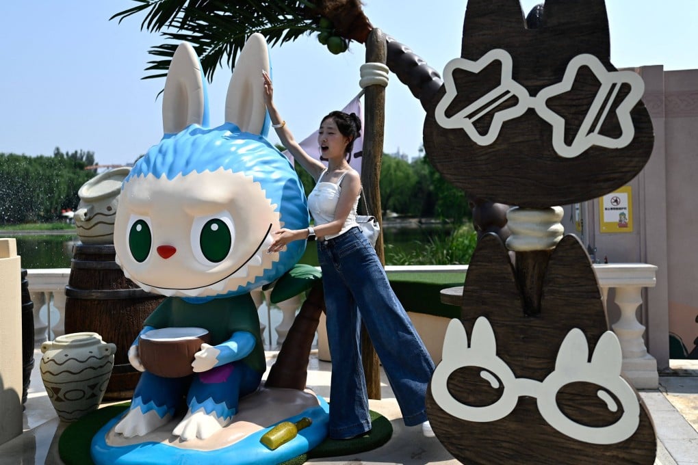 A fan poses for a picture next to the character Labubu at Pop Mart’s theme park in Beijing. Photo: AFP