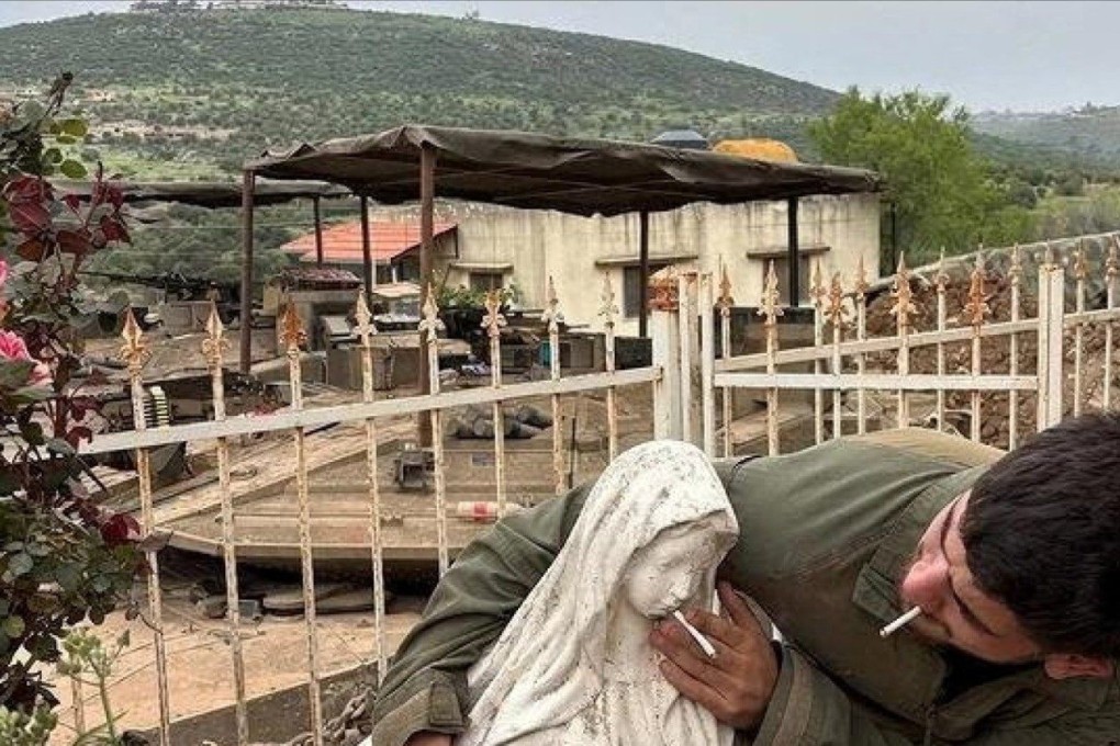 An IDF soldier appearing to put a cigarette in the mouth of a statue of the Virgin Mary. Photo: Reuters