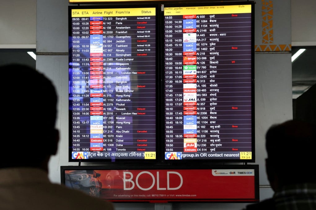 People look at a screen displaying flight information at the Indira Gandhi International airport in New Delhi on March 3. Photo: Reuters