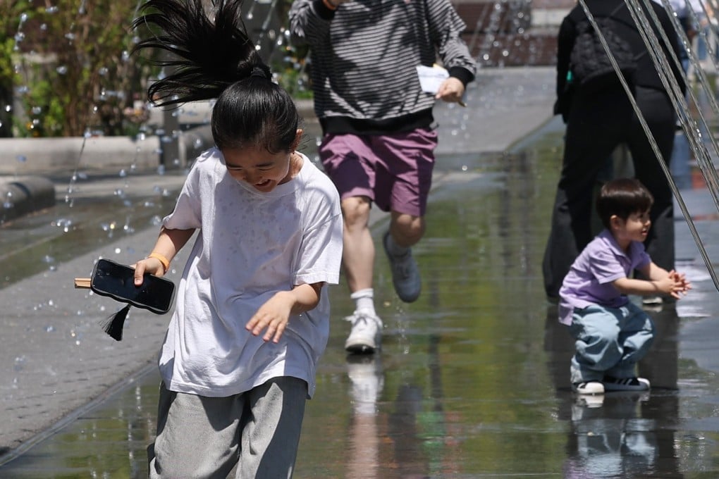 Children play in a fountain at Gwanghwamun Plaza in Seoul on April 26. Photo: Yonhap/EPA