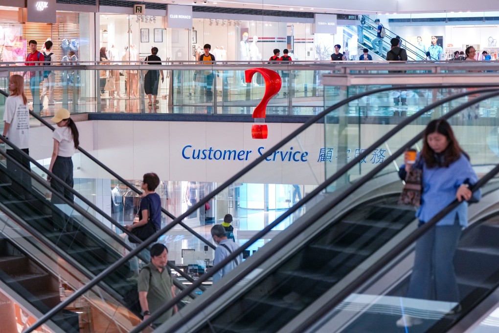 A question mark-shaped sign hangs in the air as people shop around a mall in Kowloon Tong on April 21. Photo: Sam Tsang