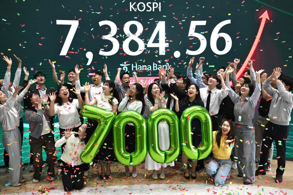 Currency dealers celebrate in front of a screen showing South Korea’s benchmark stock index during a ceremony celebrating it breaking 7,000 points at the Hana Bank headquarters in Seoul on May 6. The market value of South Korea’s Samsung Electronics smashed past US$1 trillion for the first time on May 6 as the firm rides an AI chip boom that has sent Seoul’s Kospi stock index to record highs. Photo: AFP