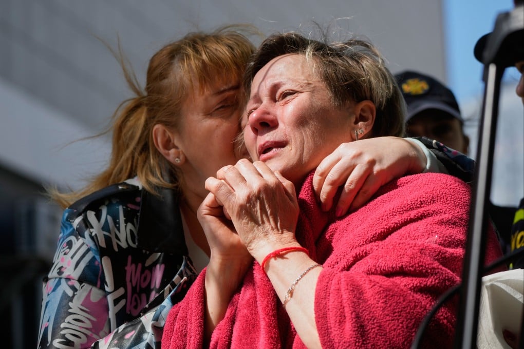 A neighbour hugs a crying woman at the site of a fatal Russian missile attack on a residential building in Kyiv, Ukraine, on Thursday. Photo: AP