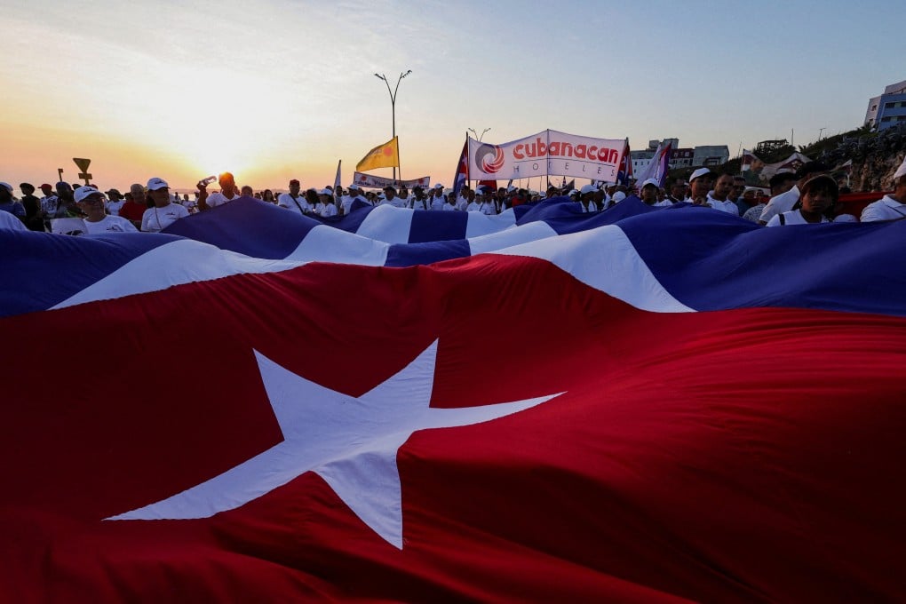 People march while holding a giant Cuban national flag during a May Day rally in Havana. Photo: Reuters