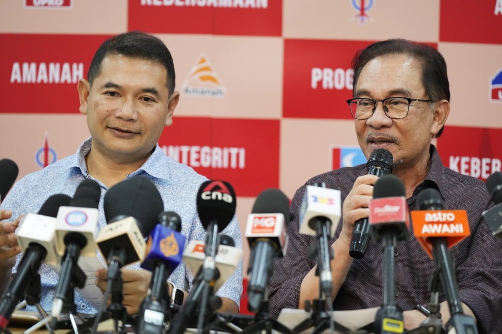 Rafizi Ramli accompanies Anwar Ibrahim as he speaks during a news conference on October 26, 2022. Photo: AP