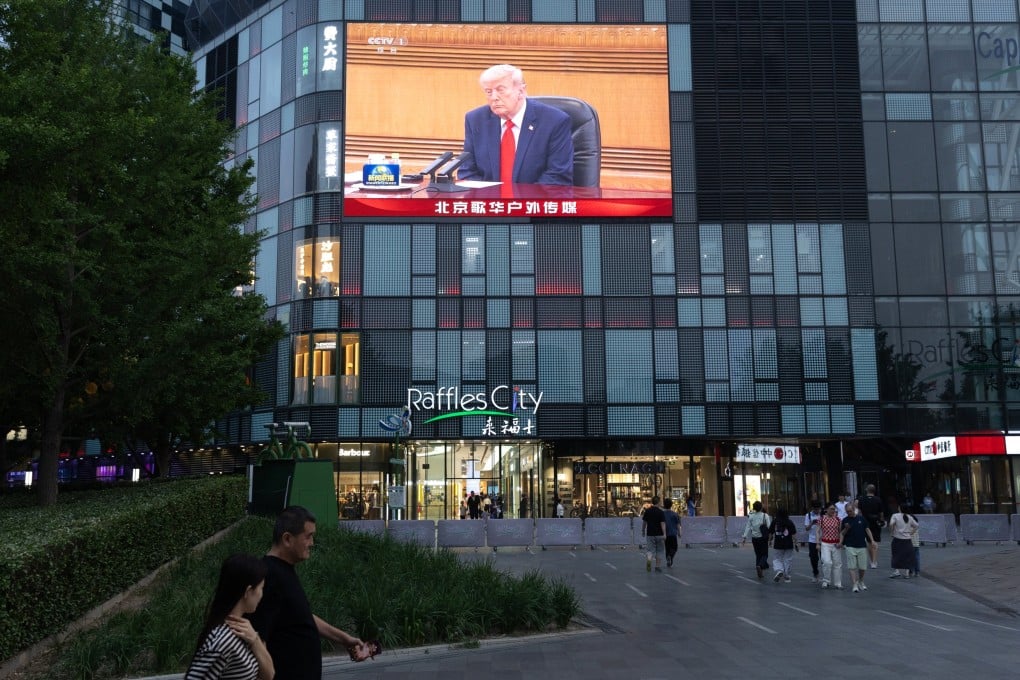 People walk past a television screen in Beijing broadcasting US President Donald Trump’s visit to China on Thursday. Photo: EPA