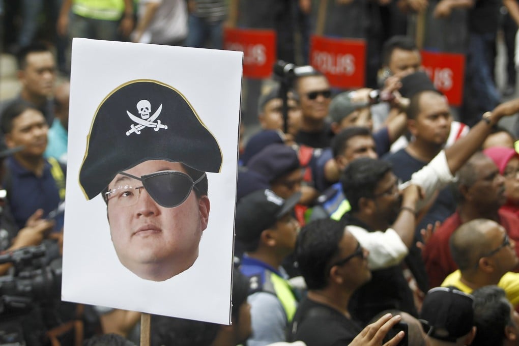 A protester holds a poster of Jho Low as a pirate during a rally in Kuala Lumpur on April 14, 2018. Photo: AP