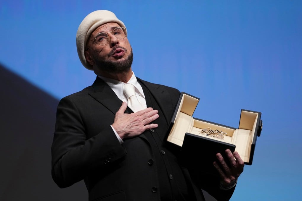 John Travolta holds his honorary Palme d’Or at Cannes on Friday. Photo: AP
