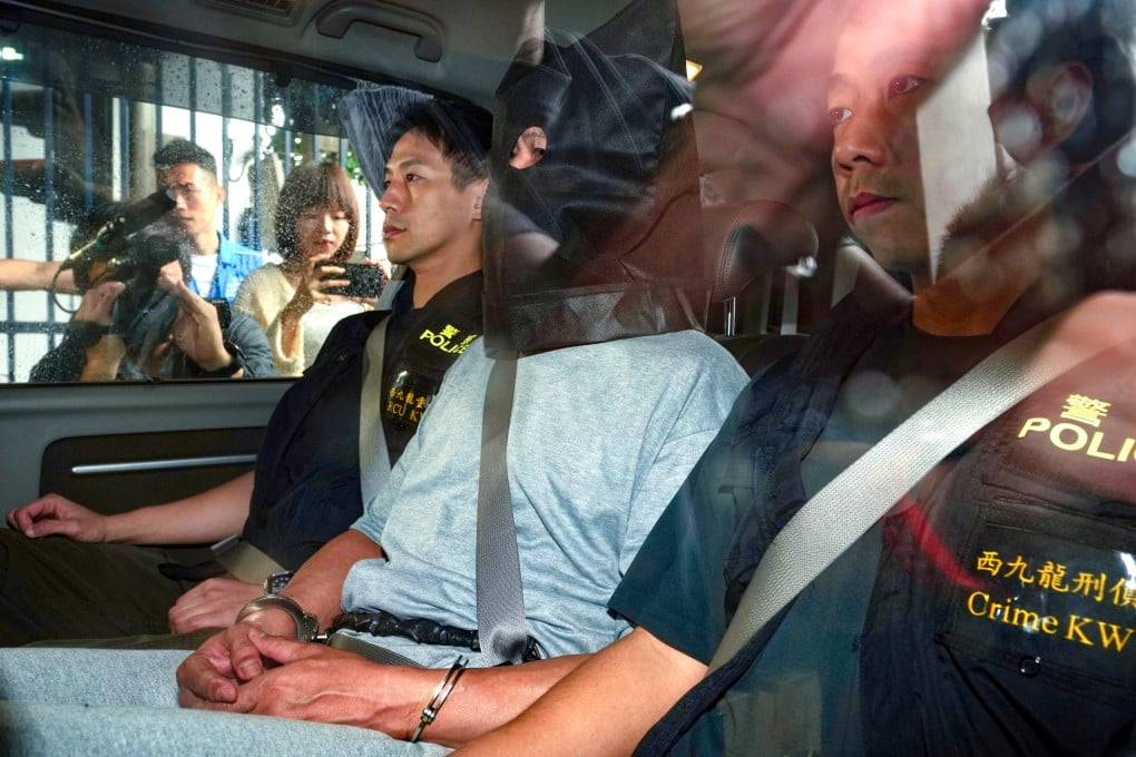 A suspect in the 1999 murder of a newspaper vendor is escorted by police officers. Photo: Sam Tsang