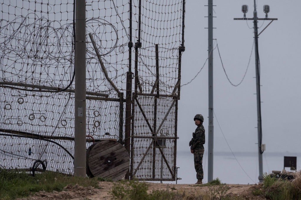 A soldier stands at a fence bordering the demilitarised zone (DMZ) separating North and South Korea in 2017. Photo: AFP