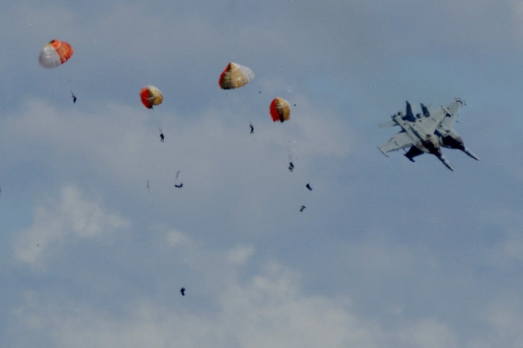 Four parachutes open in the sky as the aircraft plummet to the ground. Photo: Henk Zuurbier via Reuters