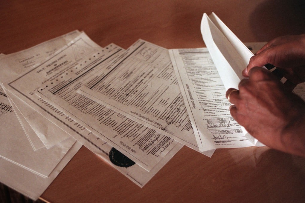 An applicant looks through H-1B visa application documents. Last year, Washington raised the H-1B application fee to US$100,000. Photo: Bay Area News Group/TNS