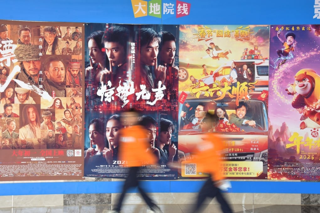 People walk past movie posters at a cinema in Mengzi city, Yunnan province on February 19. Photo: Xinhua