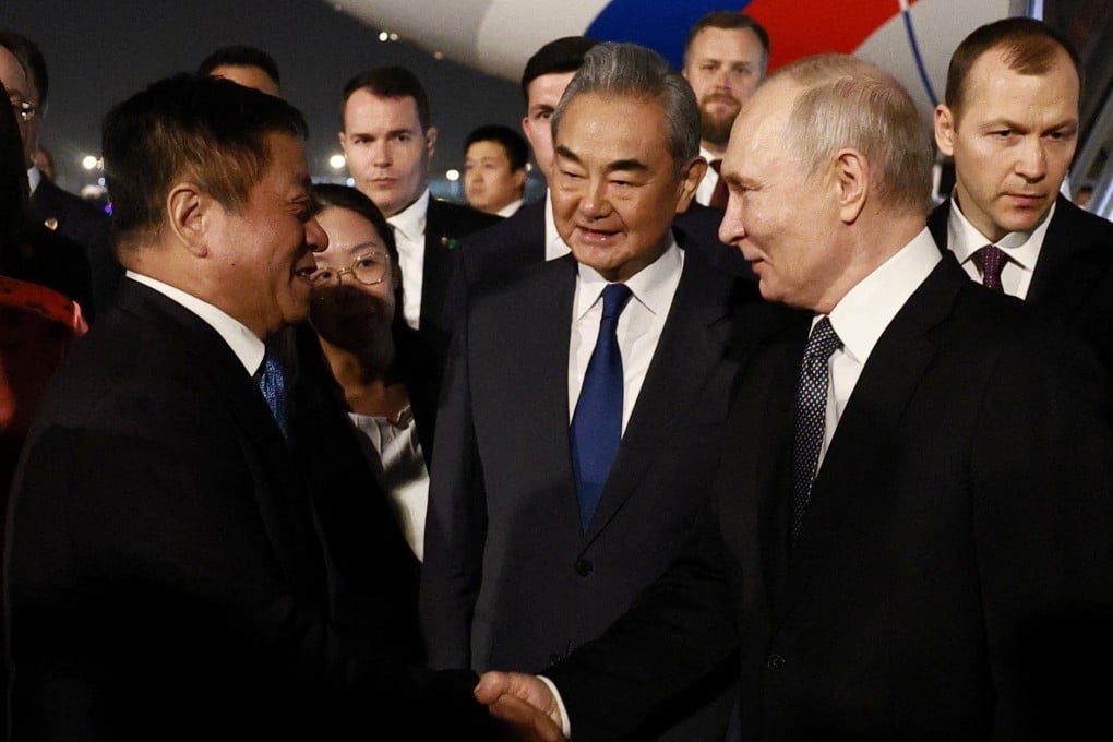 Russian President Vladimir Putin greets Chinese officials, including Foreign Minister Wang Yi, during a welcoming ceremony upon arrival in Beijing. Photo: Sputnik via Reuters
