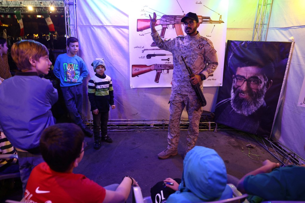 An Iranian military member gives a talk on guns at a booth in Hafte Tir Square, in Tehran on Monday. Photo: WANA/Reuters