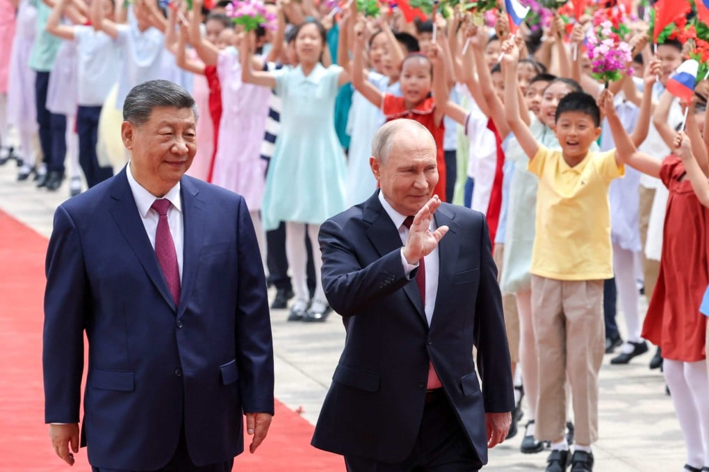 Presidents Xi Jinping and Vladimir Putin wave to a group of children at a welcome ceremony for the Russian leader in Beijing on May 20. Photo: Pool via AFP