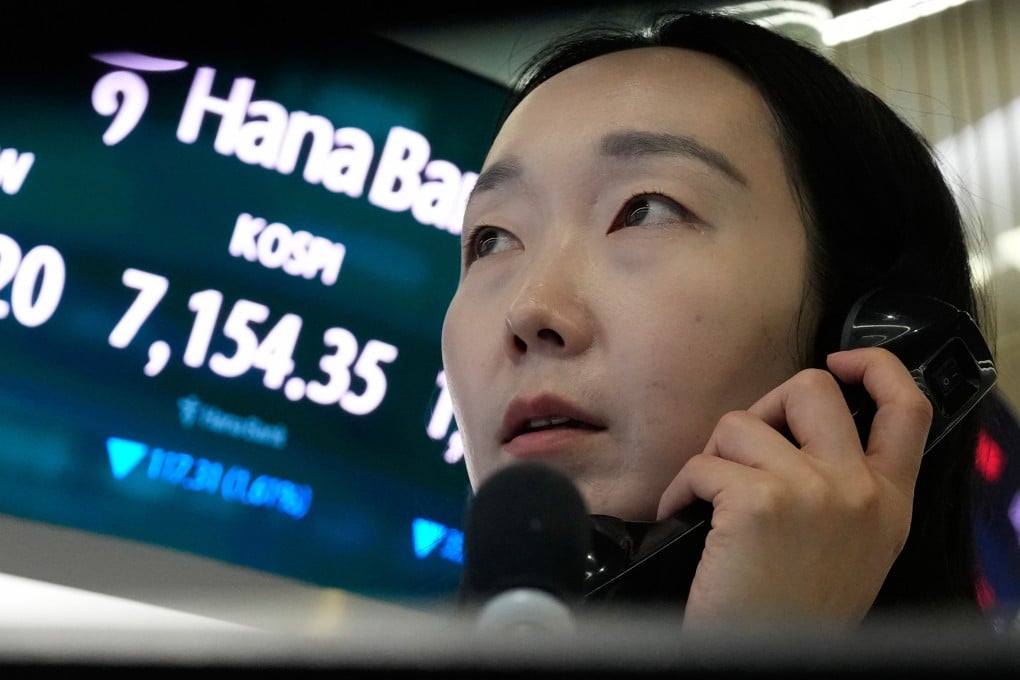 A currency trader talks on the phone near a screen showing the Korea Composite Stock Price Index and the foreign exchange rate between the US dollar and South Korean won at the foreign exchange dealing room of the Hana Bank headquarters in Seoul on May 20. Photo: AP