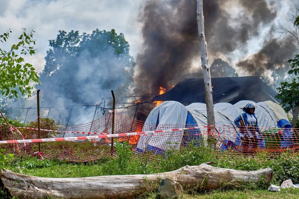 A Congolese police officer stands guard at a burning Ebola treatment centre in Rwampara, outside Bunia, Ituri province, DR Congo on Thursday. Photo: Reuters