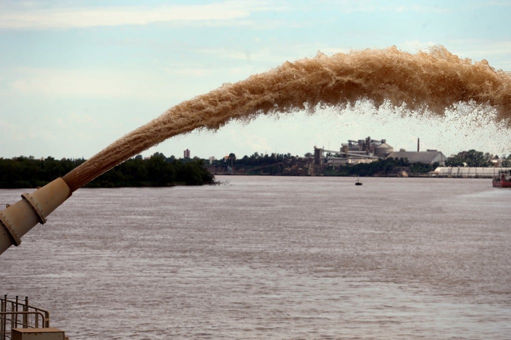 A dredging boat of the Luxembourg-based company Jan De Nul sprays sand at the shore on the Parana river near Rosario, Argentina. Photo: Reuters
